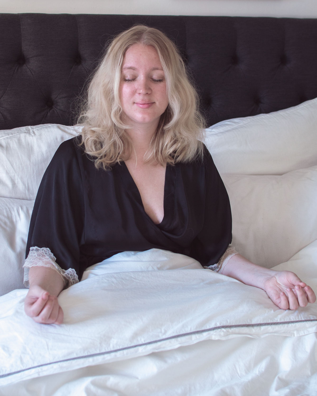 Blonde woman meditating in bed